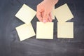 Woman posting empty adhesive notes on blackboard Royalty Free Stock Photo