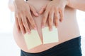 Woman posting empty adhesive notes on her pregnancy belly Royalty Free Stock Photo