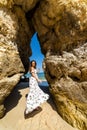 A woman tourist poses on the Praia do Camilo beach of Lagos, Portugal. Algarve region.