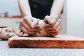 Woman potter kneads clay to create ceramic products. Potter works in a workshop