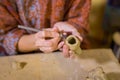 Woman potter making ceramic souvenir penny whistle in pottery workshop