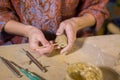 Woman potter making ceramic souvenir penny whistle in pottery workshop