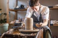 Woman potter working on Potter`s wheel making a vase. Master forming the clay with her hands creating jug in a workshop Royalty Free Stock Photo