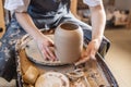 Woman potter working on a Potter`s wheel making a vase. Master pulls the jug off the circle gently holding it in hands Royalty Free Stock Photo