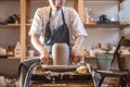 Woman potter working on a Potter`s wheel making a vase. Master pulls the jug off the circle gently holding it in hands Royalty Free Stock Photo