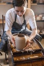 Woman potter working on a Potter`s wheel making a vase. Master pulls the jug off the circle gently holding it in hands Royalty Free Stock Photo