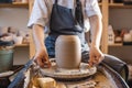 Woman potter working on a Potter`s wheel making a vase. Master pulls the jug off the circle gently holding it in hands Royalty Free Stock Photo