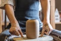 Woman potter working on a Potter`s wheel making a vase. Master pulls the jug off the circle gently holding it in hands Royalty Free Stock Photo