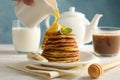 Woman pour honey on pancakes Sweet breakfast