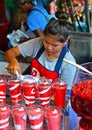 15.08.2017. woman pour strawberry smoothie with ice cream in takeaway plastic glass for sale in fruit juice shop, street food in m