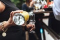 Woman pouring alcohol into glass. Closeup of female hands pouring transparent alcoholic drink from bottle. Celebration Royalty Free Stock Photo