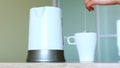 Woman pouring boiling water into a cup preraring a tea