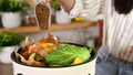 Woman pouring bokashi fermentation starter in a co