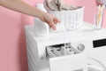 Woman pouring detergent into drawer of washing machine in laundry room Royalty Free Stock Photo