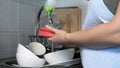 Woman Pouring Dish Soap on a Sponge in Kitchen