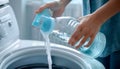 Woman pouring fabric softener from bottle into cap for washing clothes indoors, closeup. Space for text