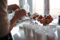 Woman pouring fresh, aromatic tea  from the ceramic teapot into white plastic cups Royalty Free Stock Photo