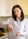 Woman pouring fresh water into a glass from decanter Royalty Free Stock Photo