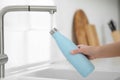 Woman pouring fresh water from tap into thermo bottle in kitchen, closeup Royalty Free Stock Photo