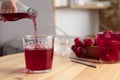 Woman pouring grape soda water into glass at wooden table indoors, closeup. Refreshing drink Royalty Free Stock Photo