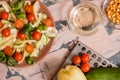 Woman pouring honey mustard dressing into bowl with fresh salad on table Royalty Free Stock Photo