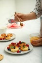 Woman pouring honey onto delicious cottage cheese pancakes at white table, closeup Royalty Free Stock Photo