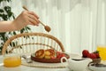 Woman pouring honey onto delicious cottage cheese pancakes at white table indoors, closeup Royalty Free Stock Photo