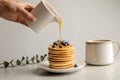 Woman pouring honey onto tasty pancakes with berries Royalty Free Stock Photo