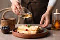 Woman pouring honey onto thin pancakes Royalty Free Stock Photo