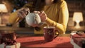 Woman pouring hot tea in a holiday cup Royalty Free Stock Photo