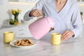 Woman pouring hot water from modern electric kettle in cup, closeup Royalty Free Stock Photo