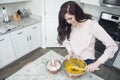 Woman pouring cake mix while cooking in the kitchen Royalty Free Stock Photo