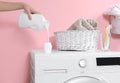 Woman pouring liquid detergent into cap on washing machine in laundry room Royalty Free Stock Photo