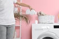 Woman pouring liquid detergent into cap on washing machine in laundry room Royalty Free Stock Photo