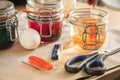 Woman pouring liquid orange Easter cold colour color in glass with water and vinegar in domestic kitchen next to green, yellow, Royalty Free Stock Photo