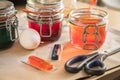 Woman pouring liquid orange Easter cold colour color in glass with water and vinegar in domestic kitchen next to green, yellow, Royalty Free Stock Photo