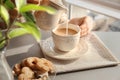 Woman pouring milk into cup with aromatic tea on table Royalty Free Stock Photo