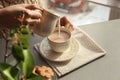 Woman pouring milk into cup with aromatic tea on table Royalty Free Stock Photo