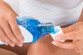 Woman Pouring Mouthwash Into Bottle Cap