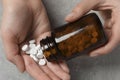 Woman pouring pills from bottle onto hand at light grey table, closeup Royalty Free Stock Photo