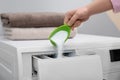 Woman pouring powder into drawer of washing machine. Laundry day Royalty Free Stock Photo