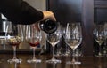 Woman Pouring Red Wine Into Four Crystal Glasses