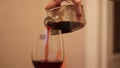 A woman is pouring red wine.