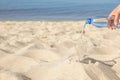 Woman pouring refreshing drink into glass on beach, space for text. Hot summer day Royalty Free Stock Photo