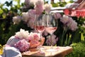 Woman pouring rose wine into glass at table in garden, closeup Royalty Free Stock Photo