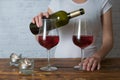 Woman pouring some red wine into her glass at romantic party with friend Royalty Free Stock Photo