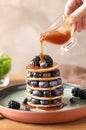 Woman pouring syrup onto tasty pancakes Royalty Free Stock Photo