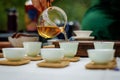 A woman pouring tea in a Chinese tea cup from a glass teapot Royalty Free Stock Photo