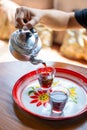 A woman pouring tea into glass on tray Royalty Free Stock Photo