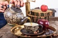 Woman pouring tea from teapot on vintage wooden table Royalty Free Stock Photo